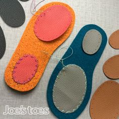 several pieces of felt with different shapes and sizes on them, including one pair of scissors