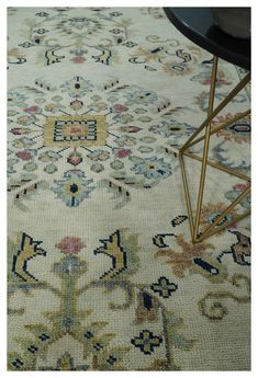 a large rug with an ornate design on the floor and side table next to it