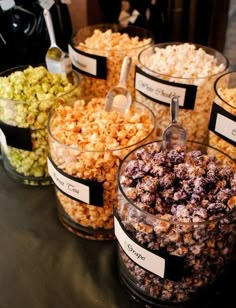 several glass containers filled with different types of popcorn