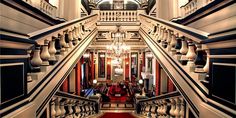 an ornate staircase with chandelier and red carpet