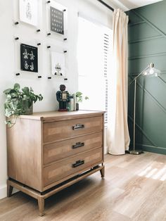 a wooden dresser sitting on top of a hard wood floor next to a green wall