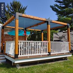 a deck with an awning over it next to a trailer