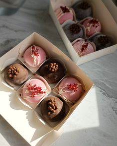 six decorated cupcakes in a box on a table