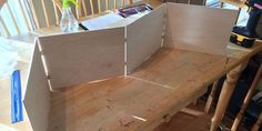 a wooden bench sitting on top of a hard wood floor next to a table and chairs