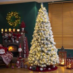 a white christmas tree in a living room decorated for the holiday season with lights and presents