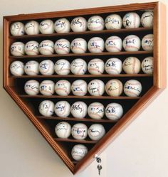 baseballs are in a wooden display case with writing on the top and bottom half