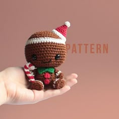 a hand holding a small crocheted christmas ornament in it's palm