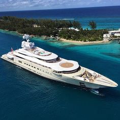 a large white boat in the middle of blue water with an island in the background