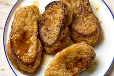 three pieces of fried food on a white plate with blue trim around the edges and sides