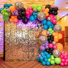 there are many balloons and disco balls on the floor in front of a mirror wall