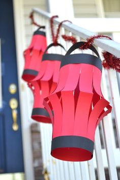 three red and black lanterns hanging from a porch