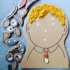 a cardboard cut out of a man's head surrounded by buttons and other crafting supplies