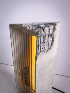 a concrete block with a metal grate on it's side and a yellow door in the middle