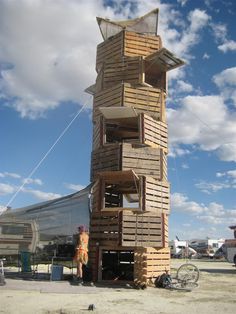 a tall wooden tower sitting on top of a dirt field