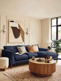 a living room with a blue couch and coffee table in front of a large window