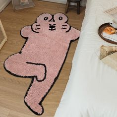 a cat rug on the floor next to a bed