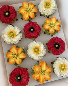 cupcakes decorated with red, white and yellow flowers