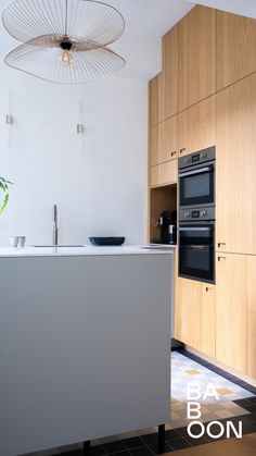 a modern kitchen with wooden cabinets and white counter tops