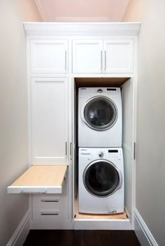 a white washer and dryer in a small space with built - in cabinets