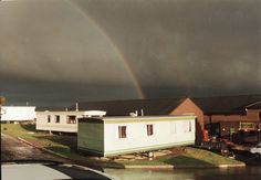 a rainbow in the sky over some houses