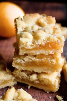 several pieces of cake sitting on top of a wooden cutting board next to an orange