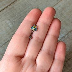 a person is holding a tiny flower shaped brooch