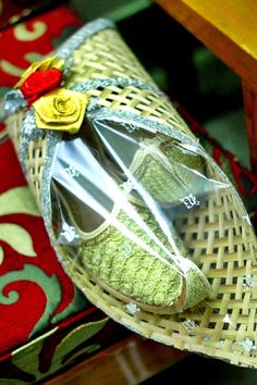 a pair of shoes sitting on top of a wooden table next to a red and green pillow