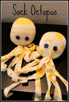 two stuffed octopus dolls sitting next to each other on top of a black table with the caption sock octopus