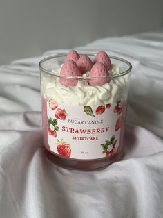 strawberry shortcakes in a glass container on a white sheet covered bed with the words sugar candle strawberry shortcake