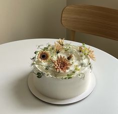 a white cake with flowers on it sitting on a table