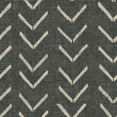 a black and white rug with an arrow pattern on the bottom, in front of a gray background