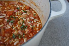 a pot filled with beans and vegetables on top of a counter