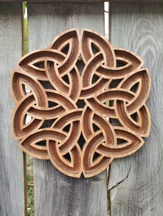 an intricate wooden design on the side of a fence