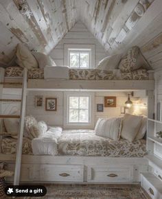 an attic bedroom with bunk beds and storage drawers on the bottom floor is decorated in white wood