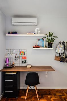 a room with a desk, chair and air conditioner on the wall above it