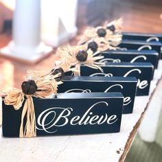 four black boxes with white lettering and burlocks tied to the sides are sitting on a table