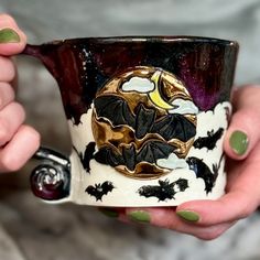 a woman holding a coffee cup decorated with bats