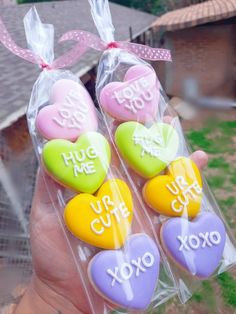 someone is holding three heart shaped candys in their hand with the words hug me, you're xoxo written on them