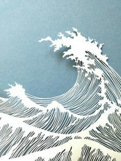 a paper cut out of the shape of a wave on a blue background with white ink