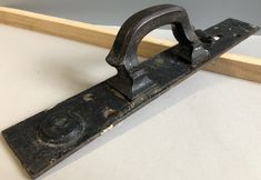 an old metal object is sitting on a table next to a wooden frame with a mirror in the background