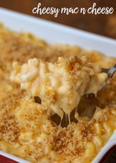 a spoon full of macaroni and cheese being lifted from a casserole dish