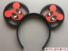 a mickey mouse ears headband with red and black faces on it's ears