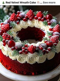 a red velvet wreath cake with white frosting and berries on top, sitting on a platter