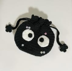 a crocheted black bag with eyes on it