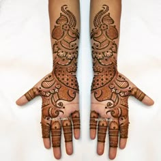 two hands with henna designs on them, one is showing the intricate design and the other has an intricate pattern