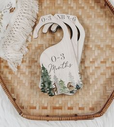 a wooden ornament with the name and date on it next to a wicker basket