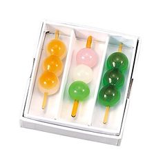 three different colored lollipops in a box