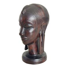 an african head sculpture is shown against a white background with the image of a woman's face in profile