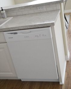 a white dishwasher sitting inside of a kitchen