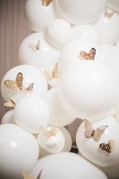 many white balloons with gold butterflies on them